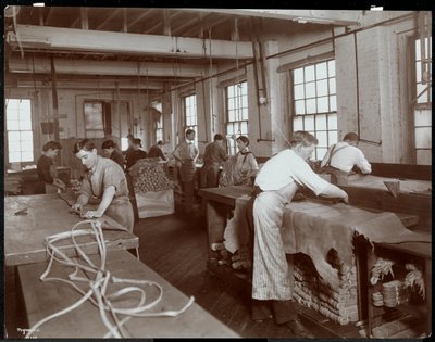 Interior view of men and women working with leather at the New York Leather Belting Co., New York by Byron Company